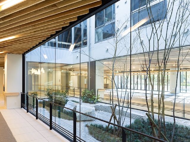 中庭が見える廊下 廊下   大きな窓越しに中庭の植栽が見える、明るい通路です。自然光が入りやすく、開放感のある動線になっています。