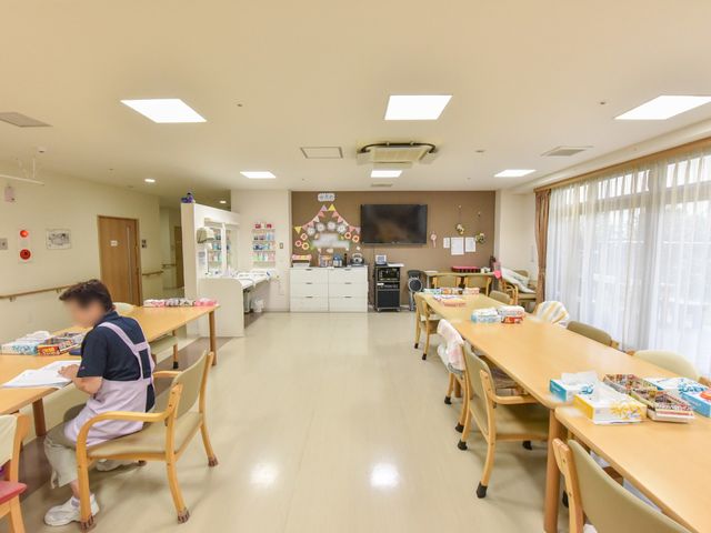 共用スペースの明るい居室 リビングルーム 広々とした居室は日の光が差し込み、居心地の良い雰囲気です。様々なレクリエーションが行われる場所で、生活の質を豊かにします。