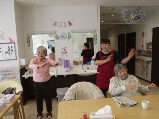 笑顔で体操する高齢者