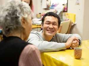 笑顔のスタッフと利用者の会話風景
