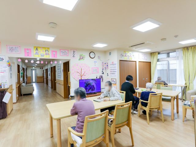 共有スペースの様子 共有スペース ゆったりとした食堂で、利用者がくつろぎながら心地よい時間を過ごしています。壁には季節感あふれる装飾が施されており、暖かい雰囲気が演出されています。