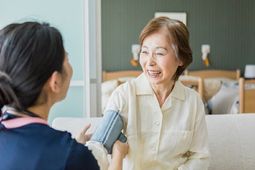 笑顔の高齢女性とスタッフ