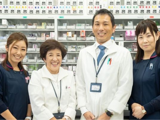スタッフの笑顔が並ぶ薬局前  
