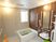サムネイル 浴室の壁は、木目調とタイル張りとが共存しているデザインである。縦横にいくつもの手すりを設置して安全面に配慮している。