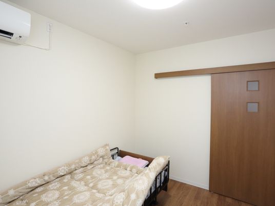 部屋の窓には、小窓が２つあり内外の電気がついているかどうかが確認できる。壁の横面にエアコンが設置してある。