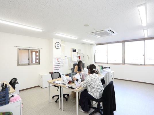 スタッフが働く明るい事務所