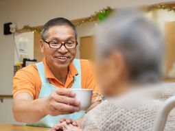 笑顔でコーヒーを提供