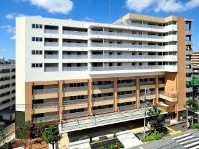 建物の外観 外観   青空の下に見える、白とベージュを基調にした大きな建物です。バルコニーが並び、落ち着いた印象の外観になっています。