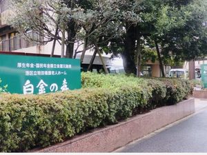 施設前の看板と植え込みの外観  