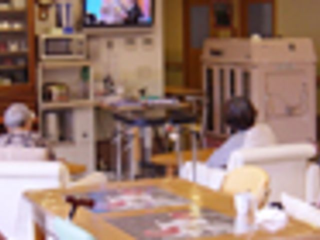 ゆったりと寛ぐ居室 居室 ソファに座ってくつろぐ方々が見られる、温かみのある居室です。共有スペースでのリラックスタイムをご提供します。