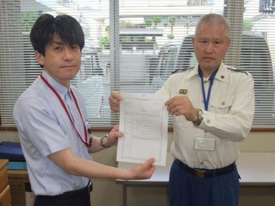 スタッフ2人の書類確認する室内  