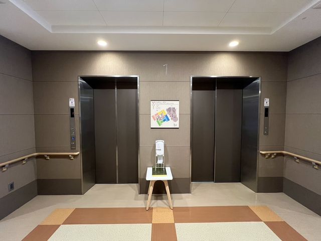 エレベーター前の様子 エレベーター 手すりが整ったエレベーター前は、安心してご利用いただける設計となっております。案内板も見やすく配置されています。