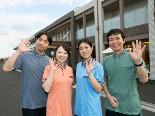 笑顔のスタッフと施設外観  