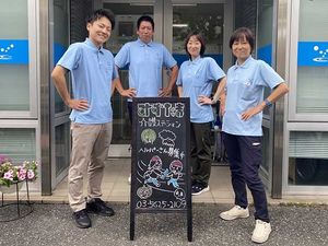 スタッフ募集の看板前の職員  