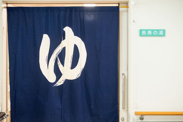 青い暖簾の浴室入口