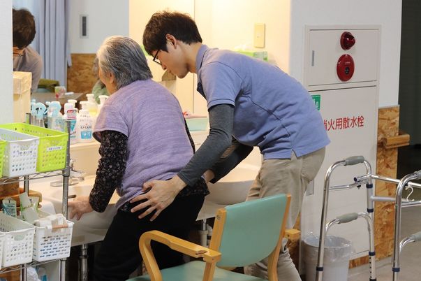 介助される高齢者と職員
