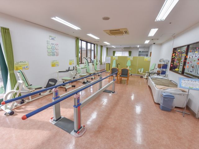 機能訓練機器が並ぶ部屋 機能訓練室 広々とした清潔感のある訓練室です。最新のリハビリ機器が整い、利用者の身体機能向上をサポートします。