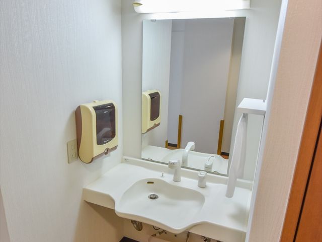 清潔な洗面台 洗面台 手すりが付いた洗面台で、安全にご利用いただける配慮が行き届いています。利便性と快適さを求める就業環境をお探しの方に最適です。
