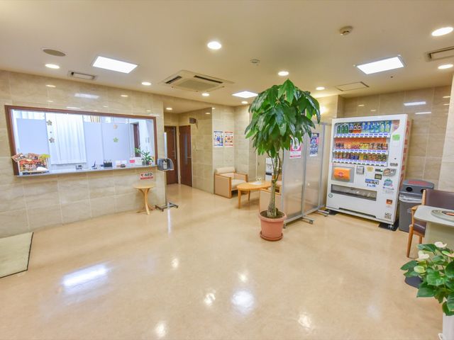 快適な休憩スペース 受付  温かみのある休憩スペースでは、清潔感のあふれる設備が揃っており、リラックスして過ごせます。自動販売機も完備され、小休憩にも適しています。