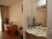 サムネイル 洗髪洗面化粧台と同じ幅の鏡が設置されている。部屋の奥には木製のデスクと収納家具が置かれているのが見える。