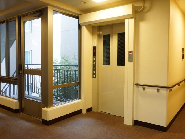 廊下にあるエレベーター エレベーター バリアフリー設計のエレベーターで、明るく清潔感のある廊下が見えます。ゆったりとした空間でご利用いただけます。