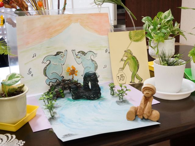 創作絵画と植物の装飾 飾り付け 手作り感のあふれるアート作品と緑の植物が並ぶ、ぬくもりのある空間です。明るい表情でお過ごしいただける環境が整っています。