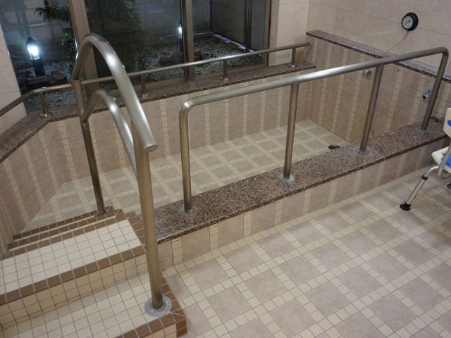 手すり付き階段の浴室 浴室 安全に配慮された設計の浴室で、手すりが設けられた階段を通って、快適な浴槽をご利用いただけます。安心して働ける環境が整っております。