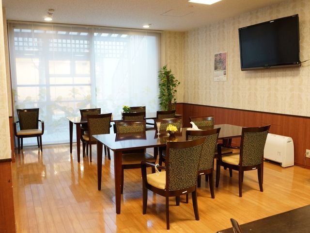 快適なダイニングスペース 食堂 自然光が差し込むダイニングで、ゆったりと食事を楽しめます。壁掛けのテレビも完備しており、明るい雰囲気が漂います。