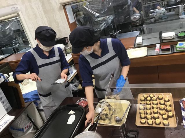 求職者向けキッチン作業風景 食堂 清潔な食堂で働くスタッフの姿が見られます。料理好きな方には充実した職場となりそうです。