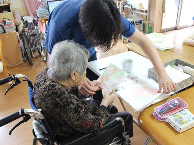 スタッフと利用者の手作業 多目的室 スタッフが一緒に制作活動をサポート。手先を使った楽しいひと時を提供しています。