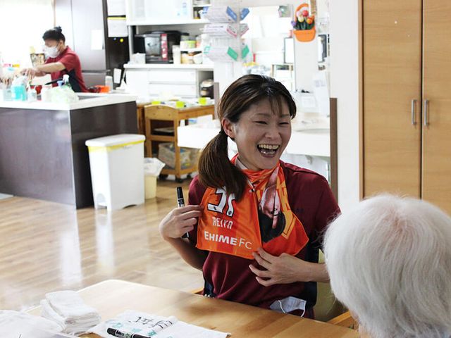 笑顔のスタッフと利用者様 スタッフイメージ スタッフが明るく対応している様子です。ご高齢の方とのコミュニケーションも積極的に取り入れています。