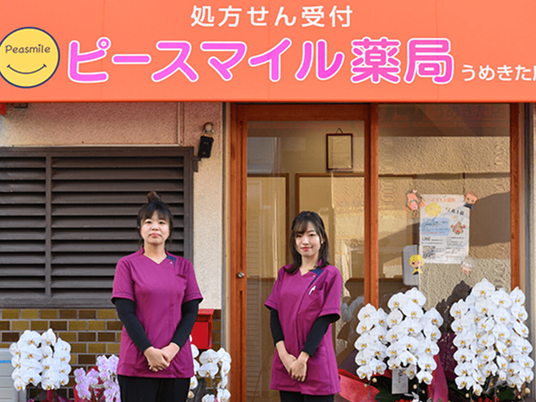スタッフが立つ薬局の入口  