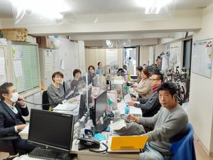 スタッフが机を囲む室内