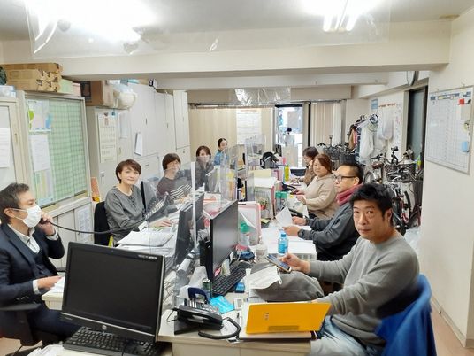 スタッフが机を囲む室内