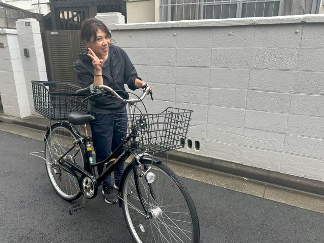 楽しく自転車に乗る女性 外観 敷地内で楽しそうに自転車を乗るスタッフの様子です。リラックスできる職場環境が整っています。
