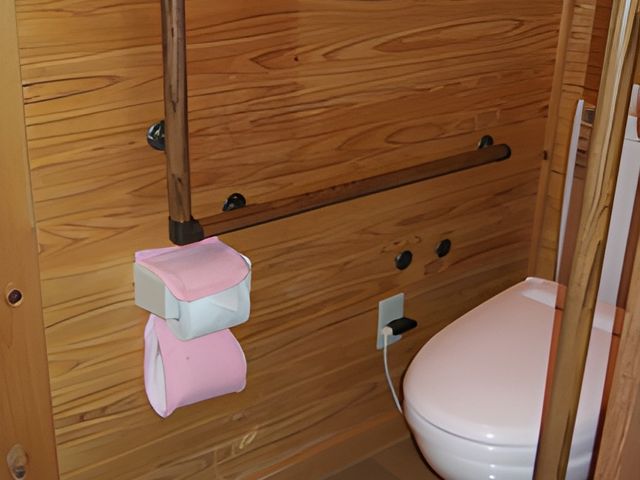 手すり付きのトイレ トイレ 手すりが付いたトイレで、安全に配慮されています。温かみのある木目調の内装です。