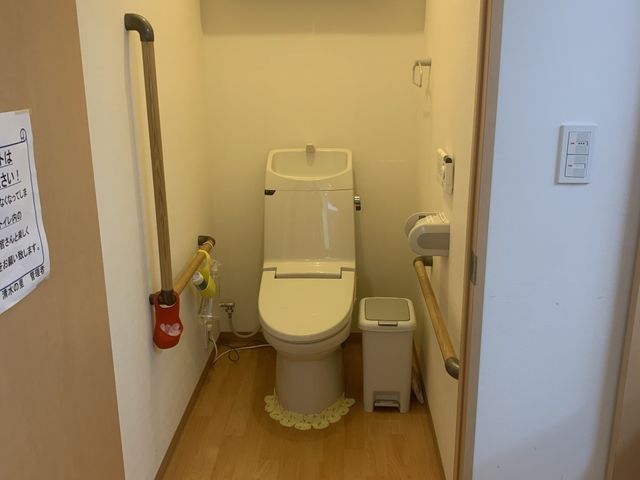 使いやすいトイレ トイレ 手すり付きで、安全に配慮された設計のトイレです。温かみのある木製の床が特徴です。