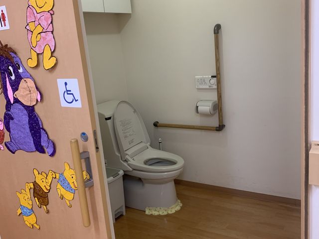 明るいトイレ空間 トイレ 壁にはかわいい装飾が施され、安心して利用できる手すりも備えています。