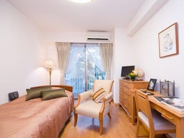快適な個室の居室 居室 落ち着いた色合いの居室は、必要な家具が整っており、快適な個人の空間を提供しています。窓からは自然光が差し込み、温もりあふれる雰囲気です。
