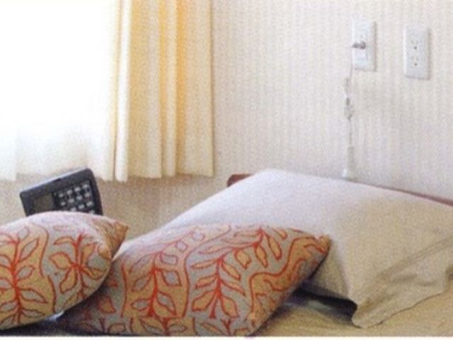 快適な居室の一角 居室 暖かみのある色合いのカーテンが特徴の居室です。リモコン付きベッドで、ご自身に合った快適な姿勢が見つけられます。