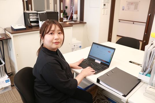 ノートパソコンを使う女性スタッフ