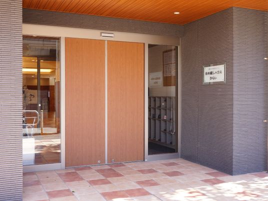 施設の入り口は自動ドアで、ガラス張りではないため外部から中が見えにくいようになっている。入り口の中に靴箱がある。