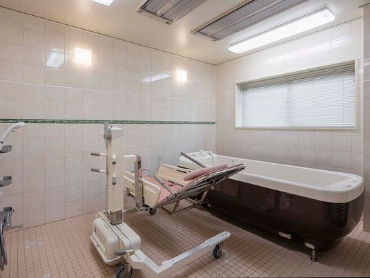 施設の写真 寝台浴が設置されているタイル張りの浴室には窓があり、明るい雰囲気。
