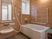 サムネイル 施設の写真 手すりがたくさん付いた一人用の浴槽が設置された浴室。オレンジの呼び出しボタンが設置されている。