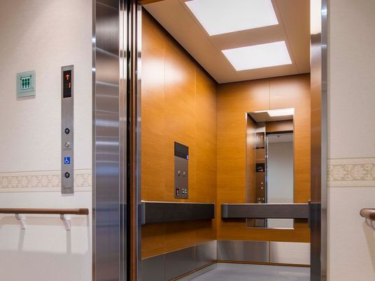 施設の写真 鏡や手すりが設置されている大きなエレベーター。操作ボタンもあり、照明も多く付いている。
