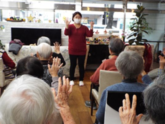 高齢者と共に体操をするリビング  