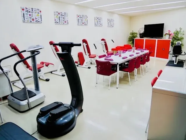 テーブルや訓練機具が置いてある 共有スぺース 豊富な経験と実績から利用者さまが自分らしく生きることを大切にしています。