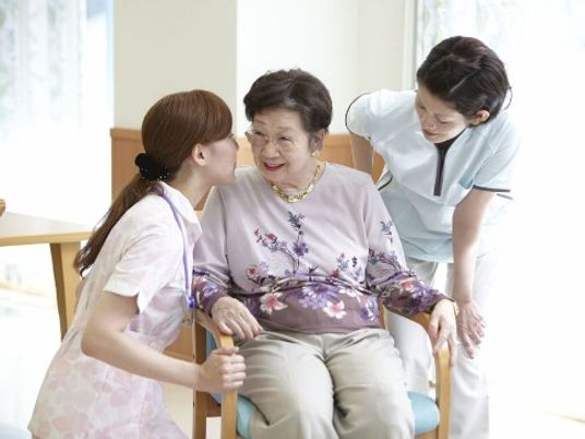 笑顔の高齢者とスタッフ二人