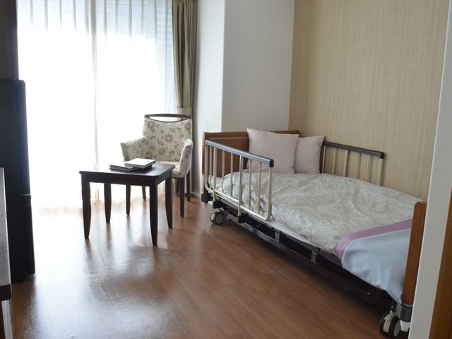 落ち着いた居室 居室 自然光がたっぷり入る居室は、リラックスできる快適な環境です。ベッドと椅子が配置されています。