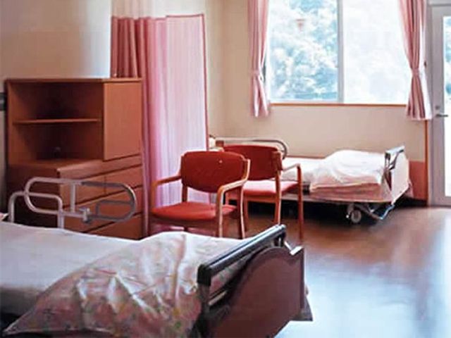 明るい居室のベッド 居室   窓から自然光が入り、明るく落ち着いた居室です。ベッドや椅子がゆったり配置され、過ごしやすさが感じられます。